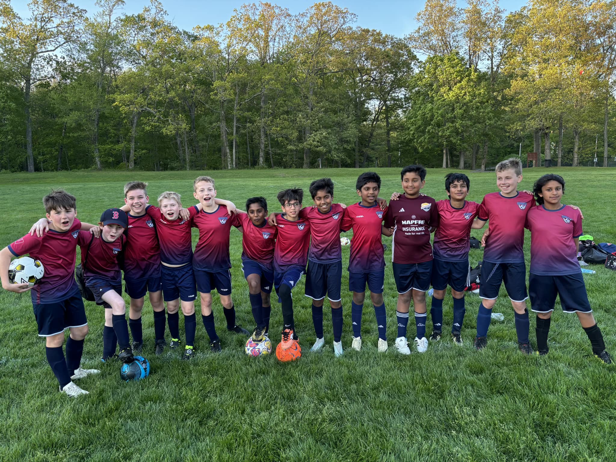 Boys grade 5-6 soccer team standing shoulder to shoulder posing together